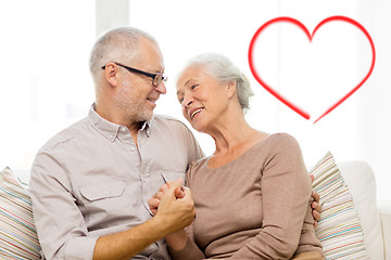 Image showing happy senior couple hugging on sofa at home