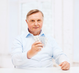 Image showing old man with pack of pills