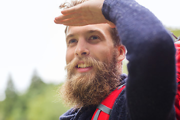 Image showing smiling man with beard and backpack hiking