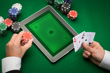 Image showing casino poker player with cards, tablet and chips