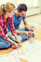 Image showing smiling couple looking at color samples at home