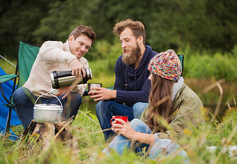 Image showing group of smiling friends cooking food outdoors