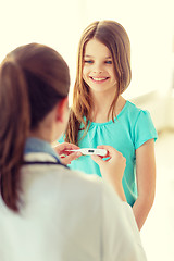 Image showing female doctor with child measuring temperature