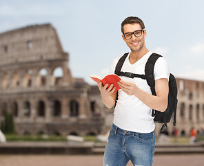 Image showing happy young man with backpack and book travelling