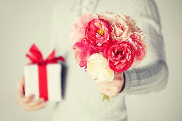 Image showing man holding bouquet of flowers and gift box