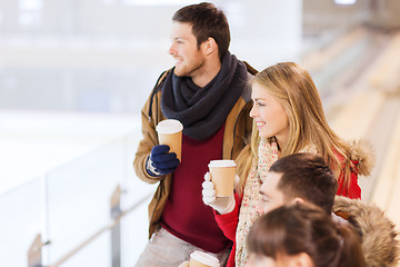 Image showing happy friends with coffee cups on skating rink