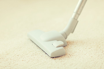 Image showing close up of male hoovering carpet