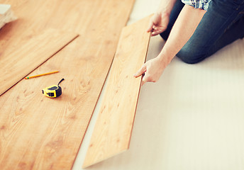 Image showing close up of male hands intalling wood flooring