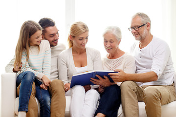 Image showing happy family with book or photo album at home