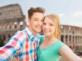 Image showing smiling couple taking selfie over coliseum