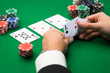 Image showing poker player with cards and chips at casino