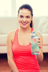 Image showing smiling girl with bottle of water after exercising