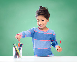 Image showing happy school girl drawing with coloring pencils