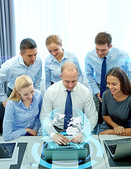 Image showing smiling business people with laptop in office