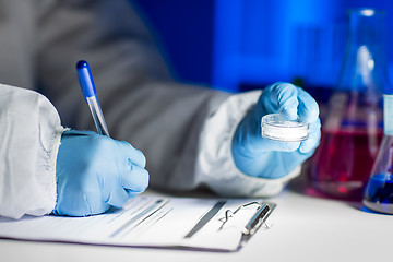 Image showing close up of scientist writing test results in lab