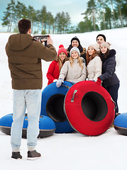 Image showing group of smiling friends with snow tubes