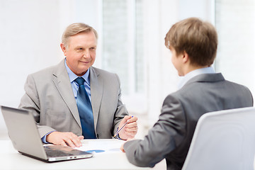 Image showing older man and young man having meeting in office