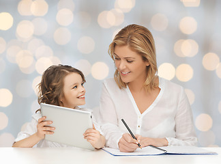 Image showing woman with notebook and girl holding tablet pc 
