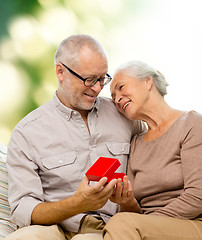 Image showing happy senior couple with red gift box