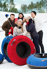 Image showing group of smiling friends with snow tubes