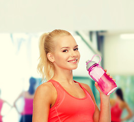 Image showing smiling sporty woman with water bottle