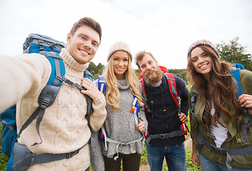 Image showing group of smiling friends with backpacks hiking