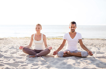 Image showing smiling couple making yoga exercises outdoors