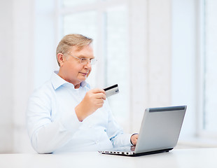 Image showing old man with laptop and credit card at home