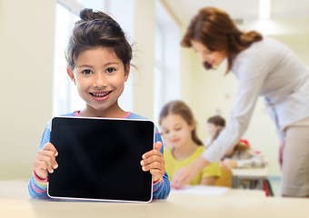 Image showing little school girl with tablet pc over classroom