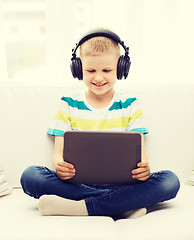 Image showing little boy with tablet pc and headphones at home