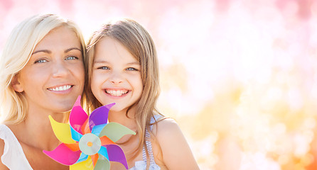 Image showing happy mother and little girl with pinwheel toy
