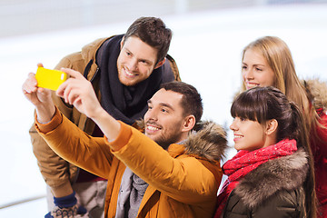 Image showing happy friends with smartphone on skating rink