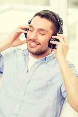 Image showing smiling young man in headphones at home