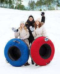 Image showing group of smiling friends with snow tubes