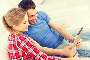 Image showing smiling happy couple with tablet pc at home