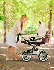 Image showing happy mother with stroller in park