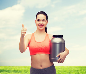 Image showing teenage girl with jar of protein showing thumbs up