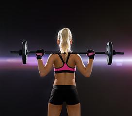 Image showing sporty woman exercising with barbell from back