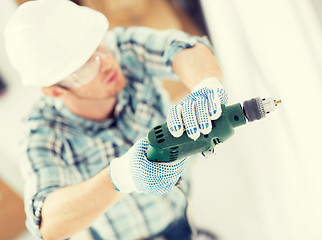 Image showing man drilling the wall