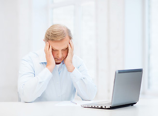 Image showing stressed old man filling a form at home