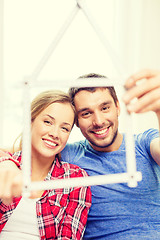 Image showing smiling couple with house from measuring tape