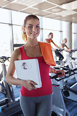 Image showing smiling woman with scales and towel in gym