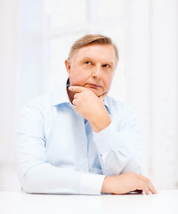 Image showing stressed old man holding head at home