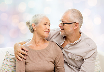 Image showing happy senior couple hugging on sofa at home