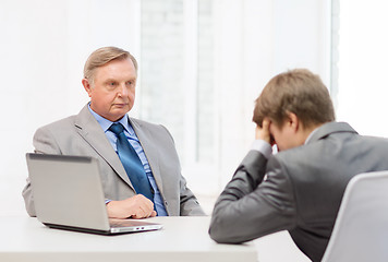 Image showing older man and young man having argument in office