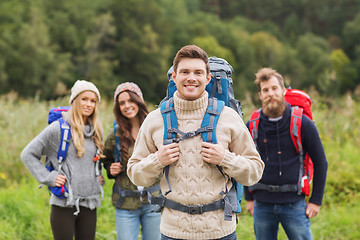 Image showing group of smiling friends with backpacks hiking