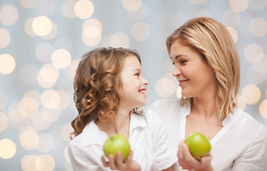 Image showing happy mother and daughter with green apples