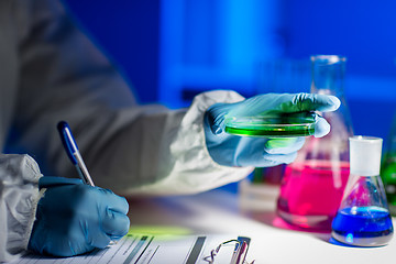 Image showing close up of scientist writing test results in lab