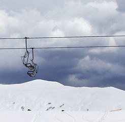 Image showing Chair lifts and off-piste slope at windy gray day