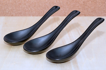 Image showing Three ceramic black spoons